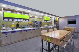霍兰Home2 Suites By Hilton Holland的一间设有桌椅的快餐店