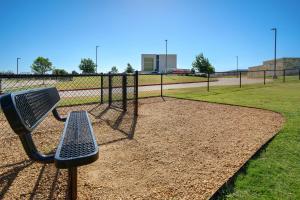 普莱诺Home2 Suites Plano Legacy West的击球笼前的公园长凳