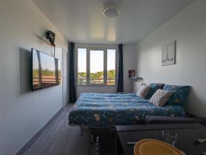 托尔西Appart tout confort très proche RER A的一间卧室配有一张床、一张沙发和一个窗口