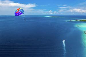 南马累环礁SAii Lagoon Maldives, Curio Collection By Hilton的风筝在水体上飞行的人