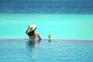 南马累环礁SAii Lagoon Maldives, Curio Collection By Hilton的坐在水里喝一杯的女人