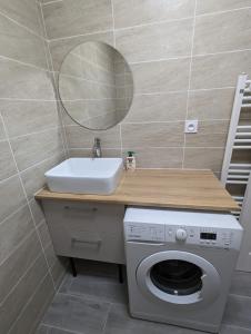 托尔西Appart tout confort très proche RER A的一间带水槽、洗衣机和镜子的浴室