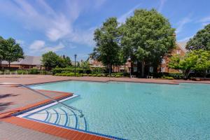 弗吉尼亚海滩芳德斯酒店及Spa的一座大游泳池,位于一个树木繁茂的庭院内
