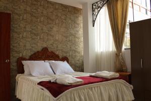 卡哈马卡Hosting Home - Casa Bella的一间卧室配有一张床,上面有两条毛巾
