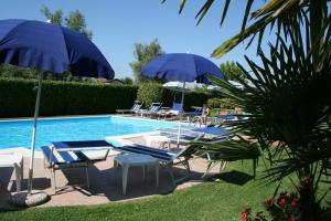 西尔米奥奈博莱罗酒店的游泳池旁设有蓝色遮阳伞和躺椅