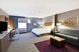 华纳罗宾斯Home2 Suites By Hilton Warner Robins的酒店客房,配有床和沙发