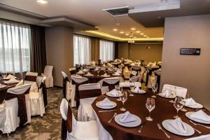 普埃布拉Hampton Inn & Suites By Hilton Puebla的大型宴会厅配有桌椅和酒杯