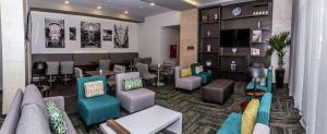 普埃布拉Hampton Inn & Suites By Hilton Puebla的大堂设有带桌椅的等候室