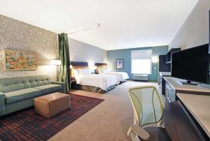 伯洛伊特Home2 Suites By Hilton Beloit的配有一张床和一台平面电视的酒店客房