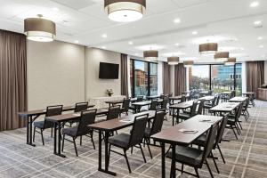 普罗维登斯Homewood Suites by Hilton Providence Downtown的用餐室配有桌椅和平面电视。