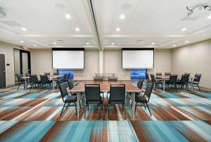伯洛伊特Home2 Suites By Hilton Beloit的一间会议室,配有桌椅和屏幕