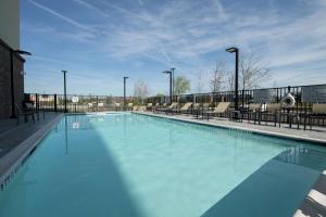 斯内尔维尔Hampton Inn & Suites Snellville Atlanta Ne的一座蓝色海水和椅子的大型游泳池