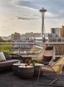 西雅图The Sound Hotel Seattle Belltown, Tapestry Collection的阳台配有桌椅,享有城市美景。