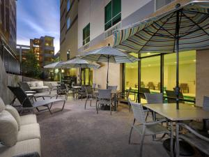 迪凯特Hampton Inn & Suites Atlanta Decatur/Emory的一个带桌椅和遮阳伞的庭院
