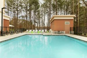 约翰斯克里克Hampton Inn And Suites By Hilton Johns Creek的一个带桌椅的大型蓝色游泳池