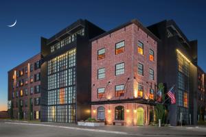 欧文NYLO Las Colinas Hotel, Tapestry Collection by Hilton的天空中月亮的大砖砌建筑