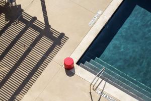 欧文NYLO Las Colinas Hotel, Tapestry Collection by Hilton的游泳池的顶部景色,旁边是红球