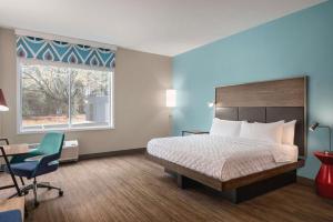 格林维尔Tru By Hilton Greenville Woodruff Road, SC的酒店的客房 - 带一张床、椅子和窗户