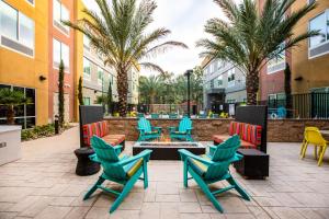 卡尔斯巴德Home2 Suites By Hilton Carlsbad, Ca的一个带椅子和火坑的庭院,并种植了棕榈树