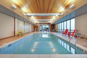 亚基马Home2 Suites By Hilton Yakima Airport的游泳池配有五颜六色的桌椅