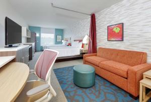 亚基马Home2 Suites By Hilton Yakima Airport的酒店客房设有一张沙发和一张床