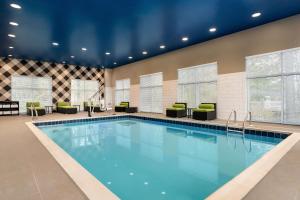 大洋城Hampton Inn & Suites Ocean City West的游泳池,酒店客房带椅子