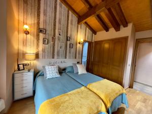 贝纳斯克拉尔达纳民宿的一间卧室设有蓝色的床和木制天花板