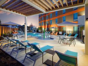 查塔努加Home2 Suites By Hilton Chattanooga Hamilton Place的一个带桌椅的庭院和一个游泳池