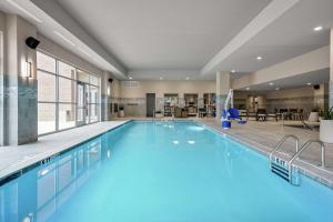 琼斯伯勒Embassy Suites Jonesboro - Arkansas State的蓝色的大游泳池,位于酒店客房内