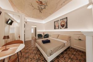 切法卢I Mori Apartments的一间卧室配有一张床,天花板上装饰有绘画作品