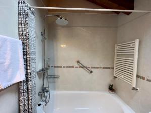 贝纳斯克拉尔达纳民宿的浴室配有白色浴缸和淋浴。