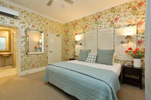 比奇沃斯Twelve on Albert的一间卧室配有一张带花卉壁纸的床