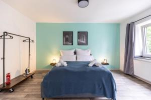 杜伊斯堡Perfekt für 2! Wifi/ Netflix的一间卧室配有一张带蓝色墙壁的大床