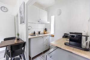 杜伊斯堡Perfekt für 2! Wifi/ Netflix的厨房配有白色橱柜和带微波炉的桌子。