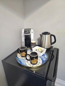 多伦多Lilen's Home的一张桌子,上面有三杯,上面有咖啡壶