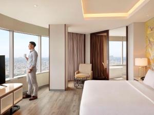 雅加达Mercure Jakarta Gatot Subroto的站在酒店房间的人