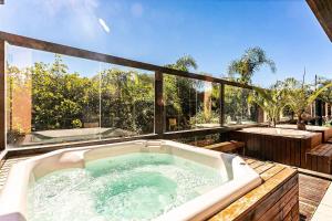 弗洛里亚诺波利斯Resort pé na areia - Studios direto com proprietário JBVJR的浴缸位于甲板上