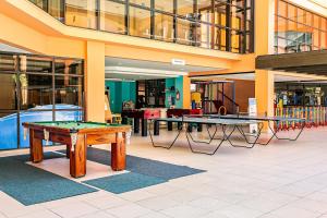 弗洛里亚诺波利斯Resort pé na areia - Studios direto com proprietário JBVJR的楼内带两张乒乓球桌的房间