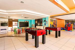 弗洛里亚诺波利斯Resort pé na areia - Studios direto com proprietário JBVJR的游戏室里设有两张乒乓球桌