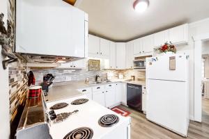 加登城Moose Haven的厨房配有白色橱柜和白色冰箱。