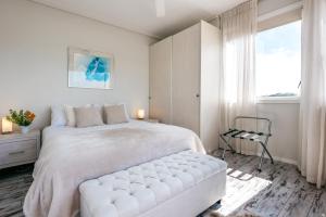 欧尼罗亚Oneroa Central - Coast & Country的白色的卧室设有一张大床和一个窗户