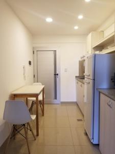 拉里奥哈DELFINA suites 1A的厨房配有桌子和蓝色冰箱。