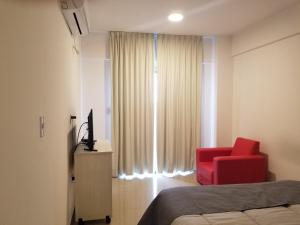 拉里奥哈DELFINA suites 1A的一间卧室配有红色椅子和窗户