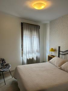 苏安塞斯Pension Amarantos的卧室配有白色的床和窗户。