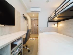 东京东京蒲田JR西口超级酒店的一间酒店客房,配有一张床和一台电视