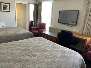 旺阿雷迪斯卡维住宿酒店的酒店客房设有两张床、一张桌子和一台电视。