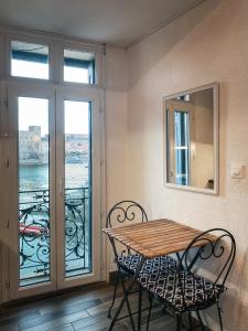 科利尤尔Résidence Collioure Plage的带阳台的客房内的桌椅