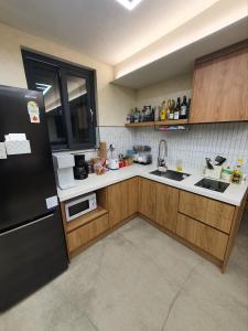 首尔Hao Guesthouse in Hongdae的厨房配有黑色冰箱和木制橱柜。