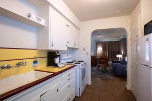 西塞德滨海汽车旅馆的白色的厨房设有水槽和炉灶。