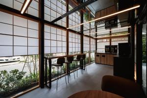 福冈THE HOTELS HAKATA Harushige Honkan的客房设有大窗户和酒吧凳子。